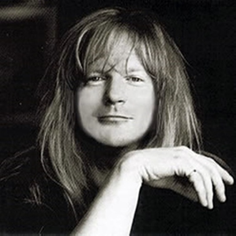 Black and white portrait of American Christian rock musician Larry Norman, looking directly forward with long blonde hair.