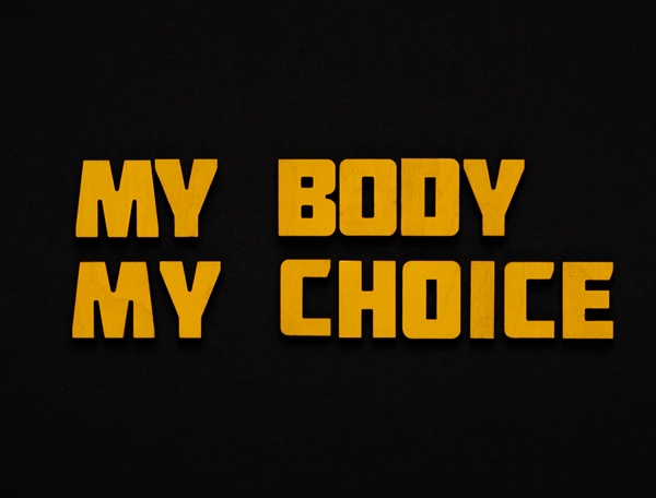 A bold black and orange graphic with the text "MY BODY MY CHOICE".